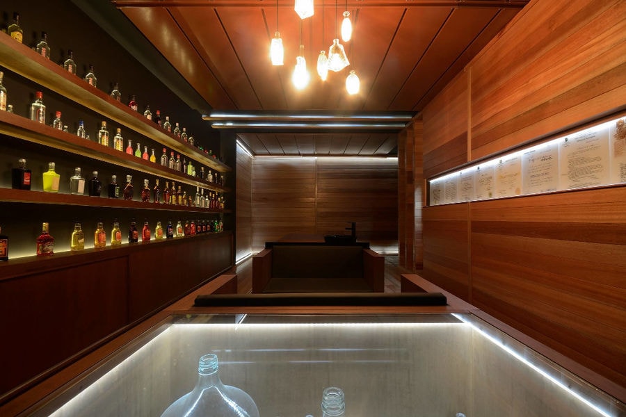 collection of old bottles on the shelves in wooden room at Callicounis Distilleries